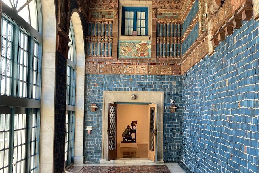 Vibrant tiled foyer at the Art Museum of the Americas with a sculpture visible through an open doorway.