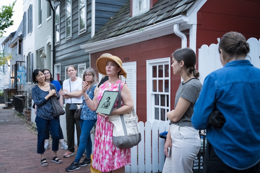 A tour guide speaks to a group during a historic walking tour in Georgetown, Washington, DC.