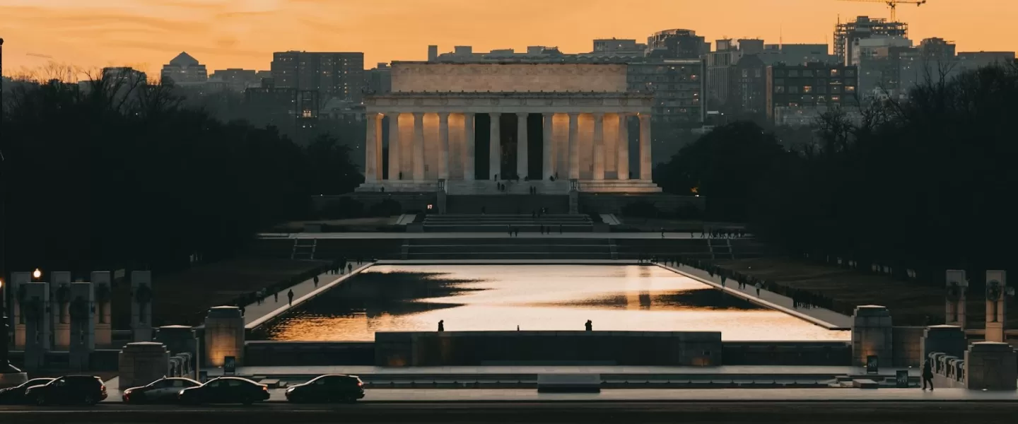 A view of the Lincoln Memorial and the reflecting pool at sunset. 