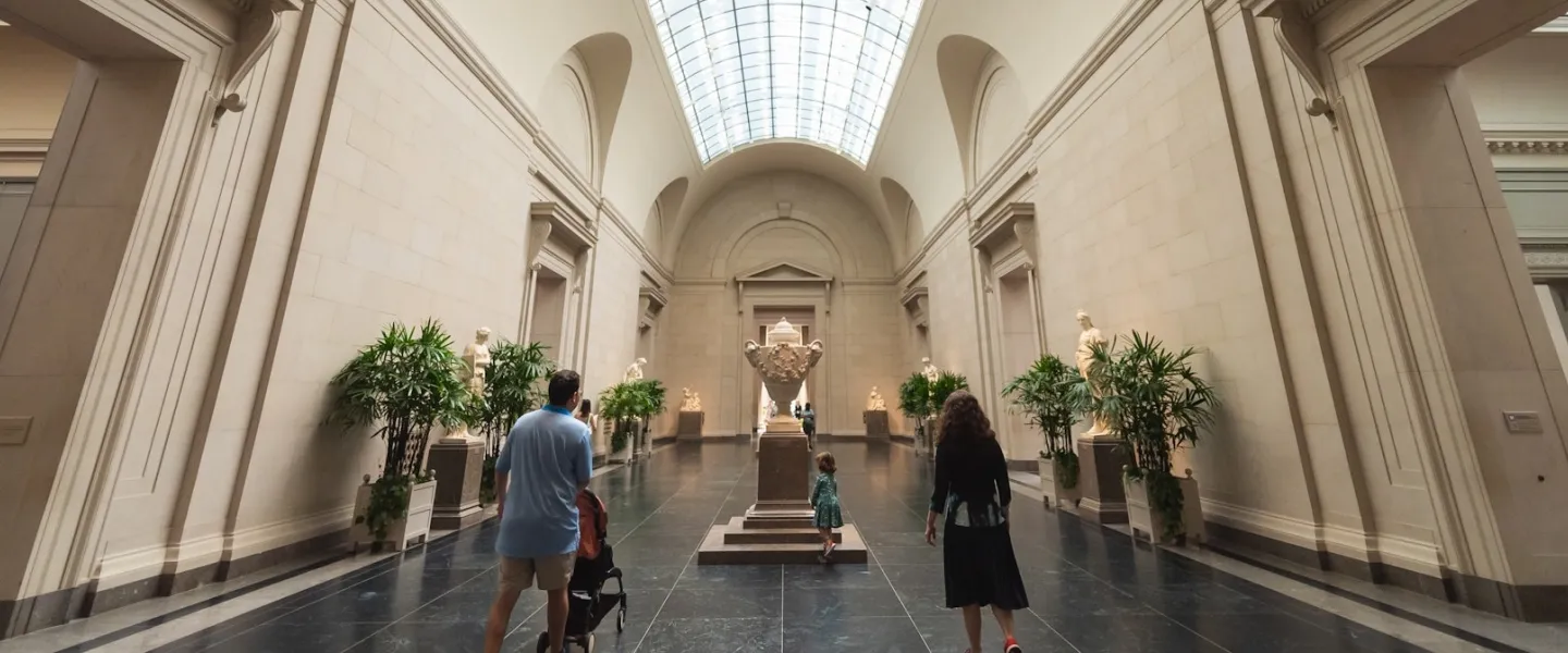 People walk down a grand hallway at the National Gallery of Art.