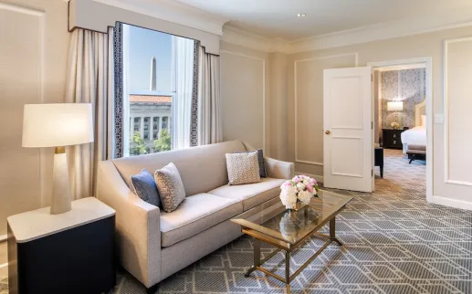An elegant hotel room with a view of the Washington Monument. 
