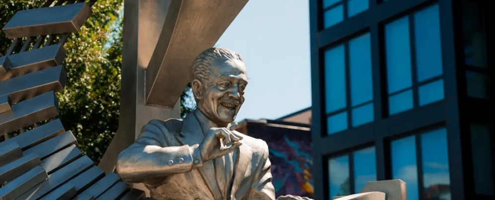 A silver-toned statue of Duke Ellington playing a grand, spiral-shaped piano stands along U Street.