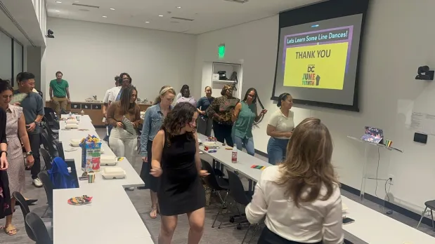Staff members line dance together during a Juneteenth celebration at Destination DC.